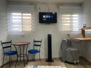 a room with three chairs and a table and a television at Hidden House Casa Escondida in Santa Rosa