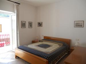 una camera da letto con un letto in una stanza con una finestra di Appartamenti La Balestra a Ischia