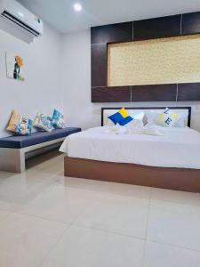 a bedroom with a large bed and a bench at The Strand Resort Samui in Ban Ko Khwan +24 photos