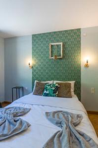 Un dormitorio con una cama y una pared verde. en Chez Mamie Wifi Un Séjour à Part, en Moyeuvre-Grande