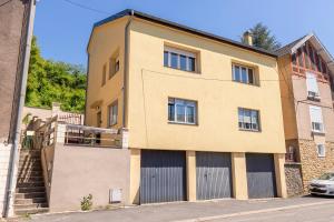 un edificio con dos puertas de garaje en una calle en Chez Mamie Wifi Un Séjour à Part, en Moyeuvre-Grande