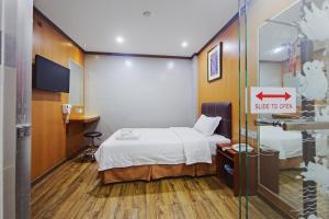 a small room with a bed and a sliding glass door at Chimera Hotel in Kota Kinabalu +2 photos