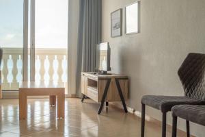 una habitación con una mesa, una silla y un espejo en Apartamentos Dominique, en La Manga del Mar Menor