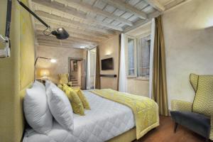 a hotel room with a bed and a chair at èROMA - PANTHEON LUXURY SUITE in Rome