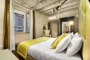 a bedroom with a bed with yellow and white pillows at èROMA - PANTHEON LUXURY SUITE in Rome
