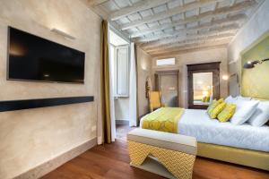 a hotel room with a bed and a tv at èROMA - PANTHEON LUXURY SUITE in Rome +11 photos