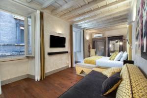 a hotel room with two beds and a television at èROMA - PANTHEON LUXURY SUITE in Rome