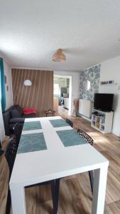 a white table in a room with a living room at Le petit paradis in Abbeville