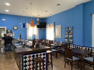 a restaurant with blue walls and wooden tables and chairs at HOTEL LOS GUILOS in Gorafe