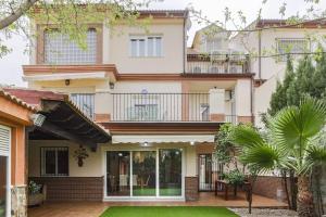 a house with a balcony and a yard at Villa Rural Las Lomas in Jaén