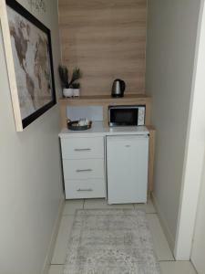 a small kitchen with a microwave and a refrigerator at Cronin Luxury accommodation Room 4 in Kimberley