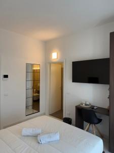 een slaapkamer met een bed, een bureau en een televisie bij Isidoro affittacamere in Carugo