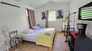 una camera da letto con un letto con una coperta gialla sopra di Tiny House, Tente Lodge & Suite, Le Paradis des Petits Voyageurs a Le Diamant