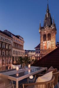a table and chairs on a balcony with a building at Turnkey I Henry's Tower Apartments in Prague