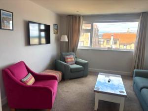 a living room with two chairs and a couch and a table at The Olde Ship Inn in Seahouses