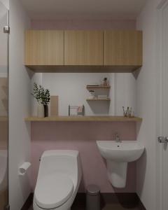 a bathroom with a white toilet and a sink at Kasa Bae in Tagaytay