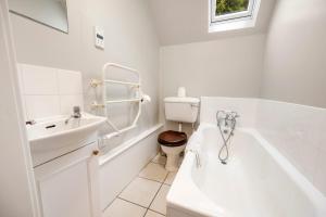 a white bathroom with a toilet and a tub and a sink at Rural 1-Bed Retreat at Stunning Raera Farm in Kilninver +11 photos