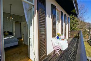 een balkon van een huis met een tafel en een bed bij Villa Leopoldina in Premeno