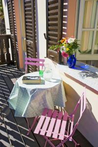 een tafel en stoelen op een patio met een tafel en bloemen bij Villa Leopoldina in Premeno