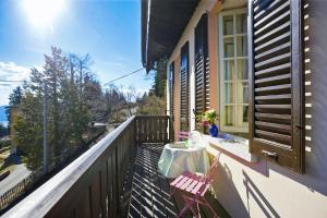een balkon met een tafel en 2 stoelen erop bij Villa Leopoldina in Premeno