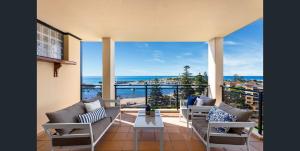 a living room with chairs and a view of the ocean at Executive Penthouse Apartment in Wollongong