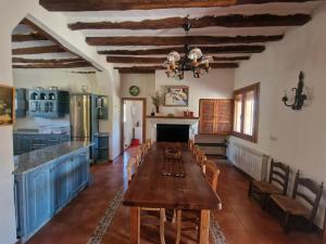 a kitchen with a long wooden table in a room at Villa Montesa in Elche de la Sierra