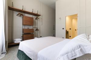 a bedroom with a large white bed and a closet at Palazzo San Giuseppe in Ostuni