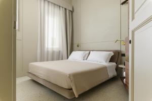 een slaapkamer met een wit bed en een raam bij Palazzo San Giuseppe in Ostuni +59 foto's