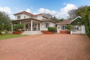 a large white house with a brick driveway at Casablanca Guest House in Durban