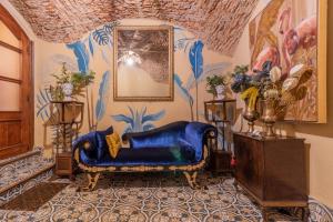 AT La Habanera By Kubik في قصرش: أريكة زرقاء في غرفة مع لوحة جدارية
