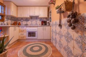 AT La Habanera By Kubik في قصرش: مطبخ بالدولاب البيضاء والبلاط الأزرق والأبيض