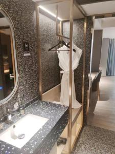 ein Badezimmer mit Waschbecken und Spiegel in der Unterkunft Yue Tower TOP PLAY eSports Hotel Beijing Road Branch in Guangzhou