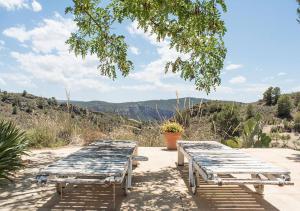 two wooden picnic tables sitting on top of a hill at Villa Montesa in Elche de la Sierra