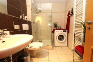 a bathroom with a toilet sink and a washing machine at Birkenhof App 44 in Wustrow +21 photos
