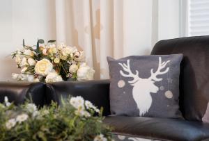 ブラウンラーゲにあるFerienwohnung am Kurparkの花が飾られたソファの上に鹿の絵が描かれた枕