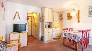 Una cocina y un comedor con una mesa y un televisor. en Croix Margot N 210 - ST4, en Villard-de-Lans