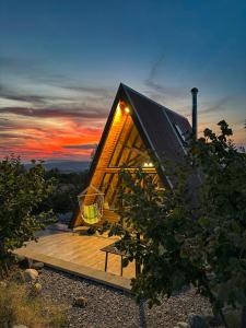a small house with a roof on a wooden deck at Алпийска вила в полите Рила in Resilovo