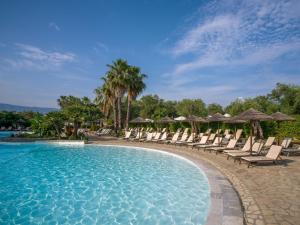 a pool at a resort with chairs and umbrellas at Hyatt Ziva Corfu in Gouvia +41 photos