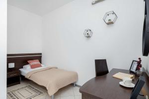 ein kleines Schlafzimmer mit einem Bett und einem Schreibtisch in der Unterkunft Spacious Villa Tarsis Studio in Kolobrzeg by Noclegi Renters in Luboszyce