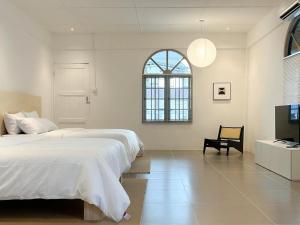 a white bedroom with a large bed and a window at Heritage Vacation Inn at Jalan Padungan in Kuching
