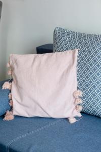 ein Kissen auf einer blauen Couch in der Unterkunft Spacious Villa Tarsis Studio in Kolobrzeg by Noclegi Renters in Luboszyce