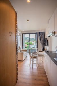 a kitchen and living room with a table and a couch at Apartment Seaview Rooftop Pool Surin beach 650m in Ban Lum Fuang