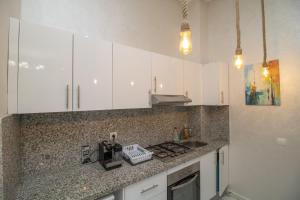 a kitchen with white cabinets and a counter top at Les rochers in Casablanca