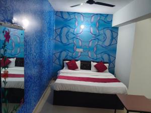 a room with a bed and a blue wall at Hotel Rudra in Haldwāni +16 photos