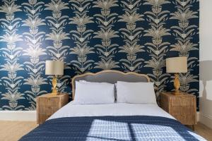 a bedroom with a blue and white damask wallpaper at 15 Pittville Lawn in Cheltenham
