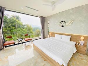 a bedroom with a large bed and a large window at Rolling Hill Resort in Xóm Trông