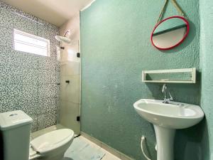 une salle de bain avec toilettes, lavabo et miroir dans l'établissement Maga Inn House - Centro, à Blumenau 110 autres photos