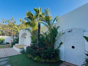 a palm tree in the courtyard of a house at MerSea Villa -Brand new Balangan beach -luxurious 4 bdr with huge pool in Perean