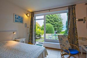 ein Schlafzimmer mit einem Bett und einem großen Fenster in der Unterkunft Villa Panorama in Porto Valtravaglia