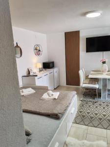 a living room with a table and a living room with a room at Family studio apartman in Karlovac